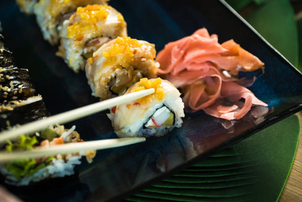 istock Sushi Set. Various rolls on a wooden plate. On dark rustic background 1183304558