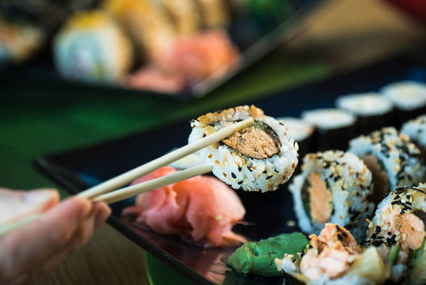 istock Sushi Set. Various rolls on a wooden plate. On dark rustic background 1183305276