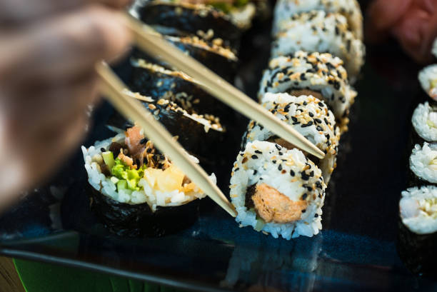 istock Sushi Set. Various rolls on a wooden plate. On dark rustic background 1183305409