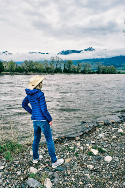 Senior woman relaxing beside the Yellowstone River at Paradise Valley, Montana, USA.