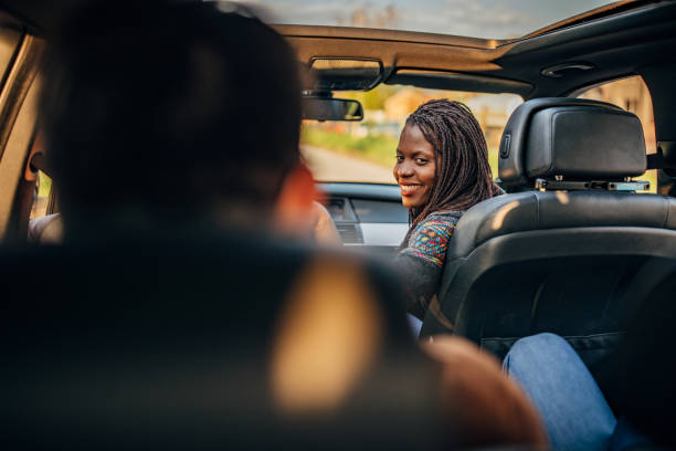 Friends riding in a car together Group of friends driving in a car together black taxi stock pictures, royalty-free photos & images