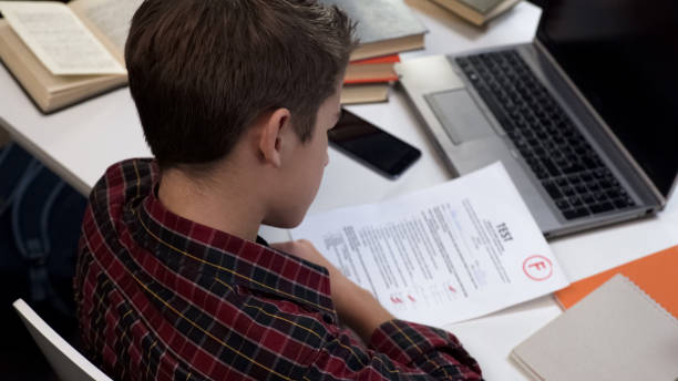 istock Sad school pupil looking negative test result upset bad mark, education system 1183307430