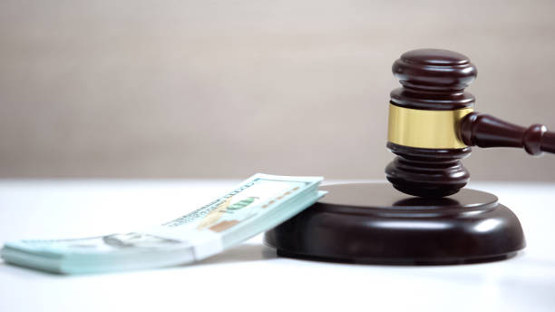 istock Bunch of dollars on table, gavel standing on sound block, damage compensation 1183307556
