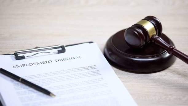 istock Employment tribunal document on table, gavel lying on sound block, labour law 1183307594