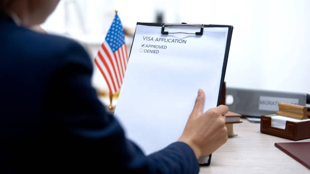 istock Immigration officer approving visa application, american flag on table, tourism 1183307647
