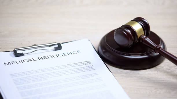 istock Medical negligence document on table, gavel lying on sound block, damage 1183307724