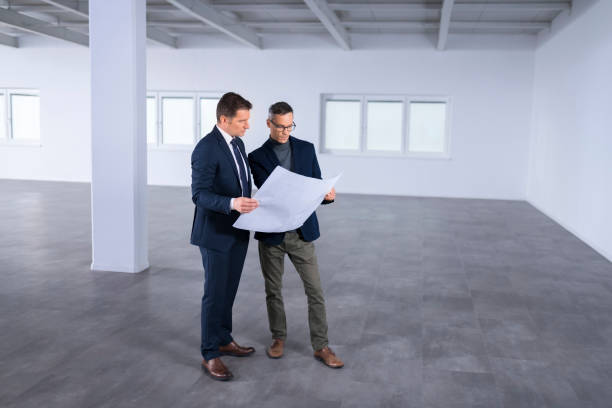 istock Businessmen discussing blueprint 1183311525