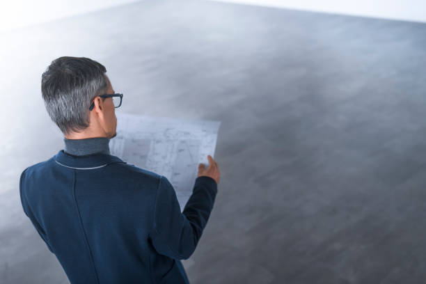 istock Businessman reviewing blueprint 1183311531