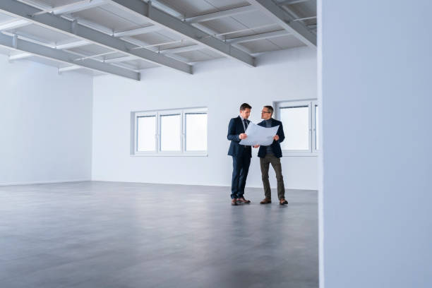 istock Businessmen discussing blueprint 1183311563