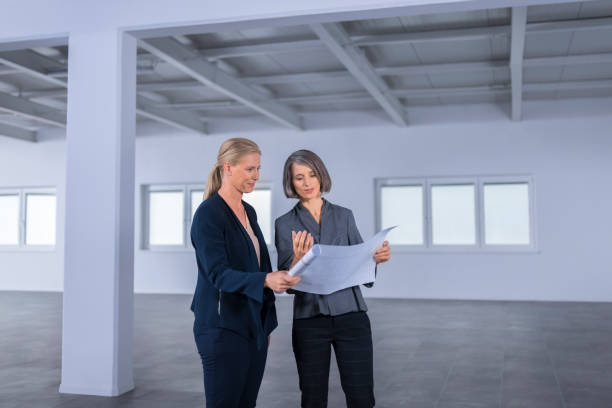 istock Businesswomen discussing blueprint 1183311570