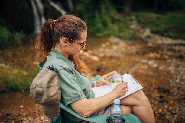 istock Woman biologist taking notes in nature 1183313790