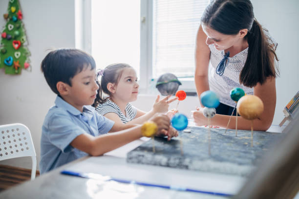 istock Teacher and two children on science class in private elementary school 1183313891