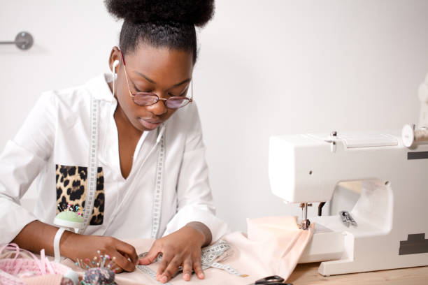 istock african seamstress working with fabric takes measures 1183318032