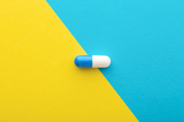 istock Pharmaceutical pill on yellow blue background 1183318456