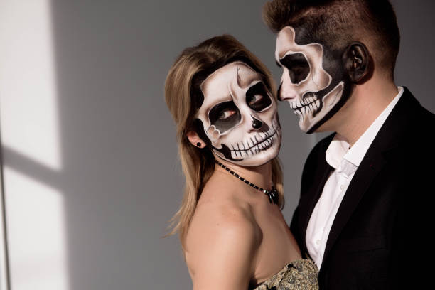 istock Couple with dark skull makeup on white background. Halloween 1183318801