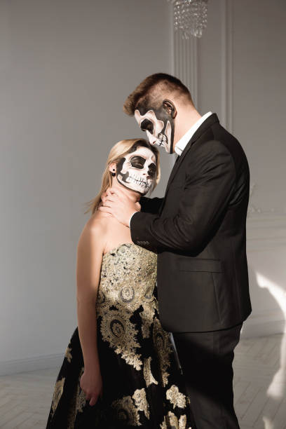 istock Couple with dark skull makeup on white background. Halloween 1183319022