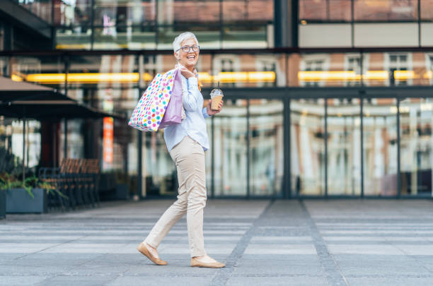 Senior woman shopping Smiling mature woman with shopping bags mall walker stock pictures, royalty-free photos & images