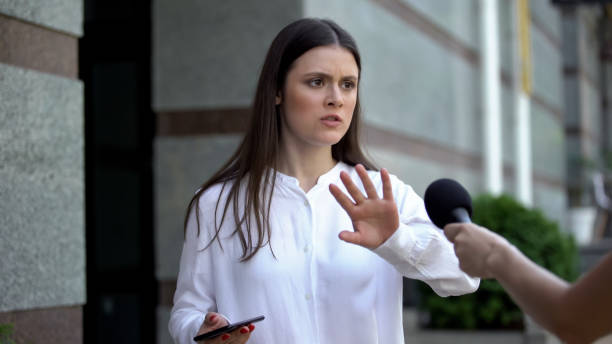 istock Female going out from apartment rejecting to give interview, arguing with press 1183325210