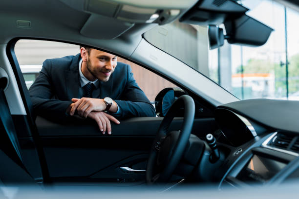 istock selective focus of cheerful bearded man looking at modern car 1183325385