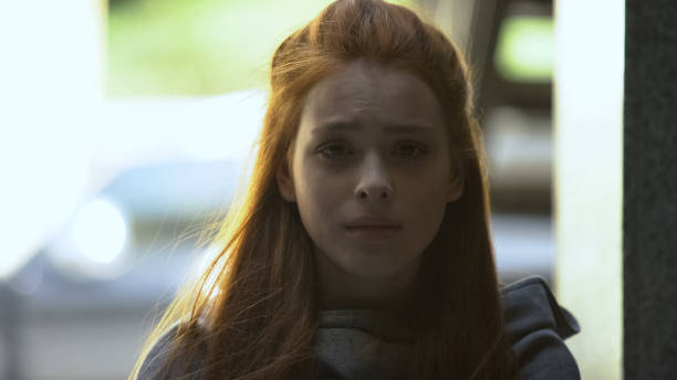istock Lonely young female deeply crying outdoor, sadly looking into camera, problems 1183325483