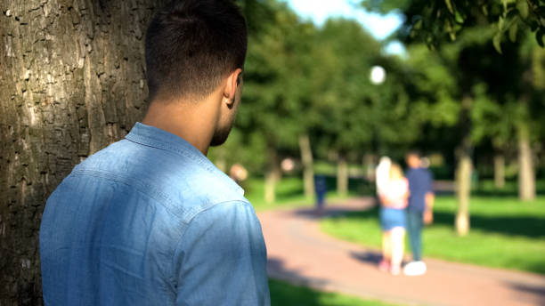 Man secretly spying loving couple walking on date outdoors, jealous ex-boyfriend Man secretly spying loving couple walking on date outdoors, jealous ex-boyfriend stalker stock pictures, royalty-free photos & images