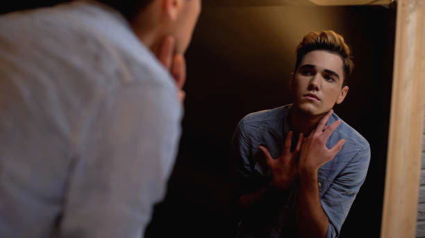 istock Upset gender fluid person looking in mirror and crying, self-identity problems 1183326866
