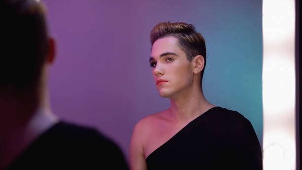 istock Genderqueer with half-face makeup looking in mirror, non-binary identity concept 1183326933