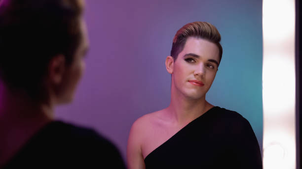istock Travesty diva with half-face make-up looking at mirror reflection before show 1183326936