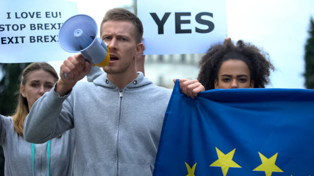 mann mit megafon skandiert menschenrechtsslogan schwenkt flagge, rechtsvorherrschaft in der eu - political rally fotos stock-fotos und bilder