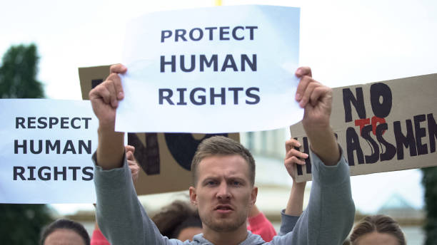 istock Activists chanting human rights slogan holding banners, rally against harassment 1183326998