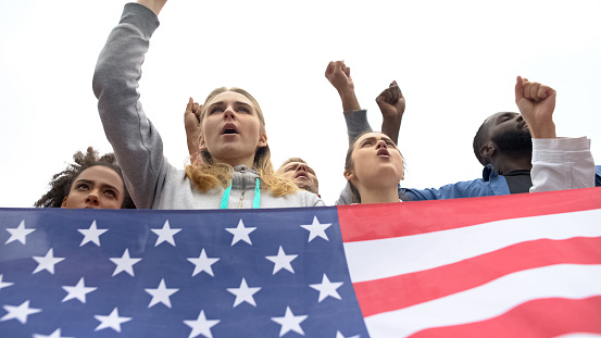 Active citizens holding USA flag and chanting slogans, protest or rebellion