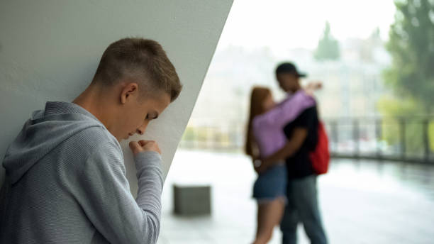 istock Angry male student looking at girlfriend embracing classmate love disappointment 1183327721