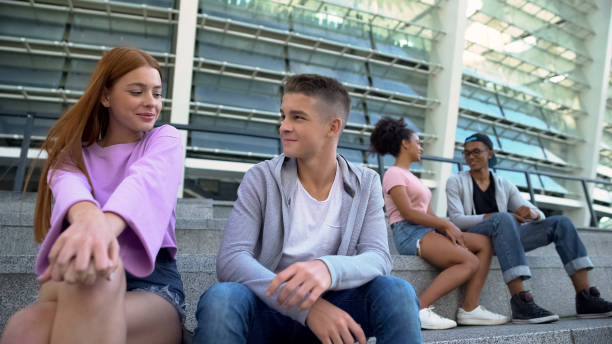 istock Young college students on outdoors date talking sitting campus stairs, flirting 1183327779