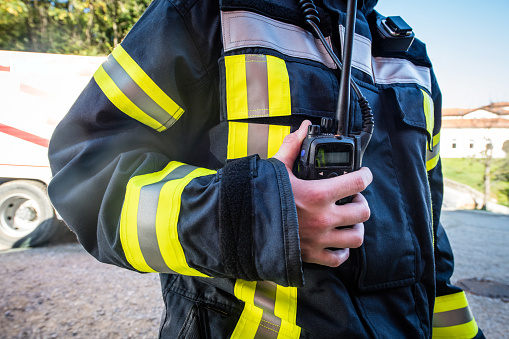 Firefighter using a walkie talkie, emergency call; all logos removed. Slovenia, Europe. Nikon.