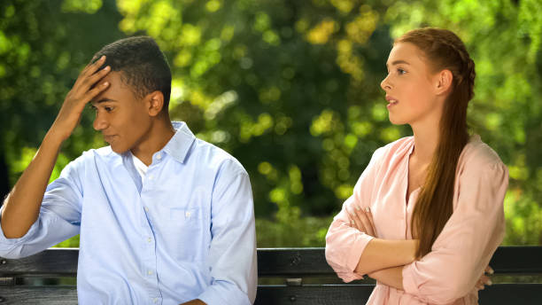 istock Teenagers couple quarreling sitting on bench in park, relations problem break up 1183329152