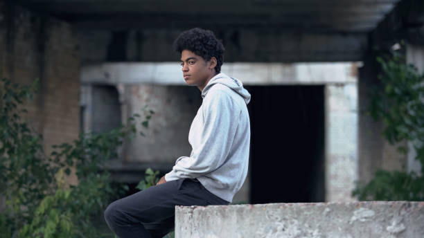 Hispanic boy sitting on some ruins looking at the horizon,