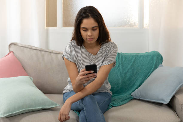 istock Young woman at home using a smartphone 1183334224
