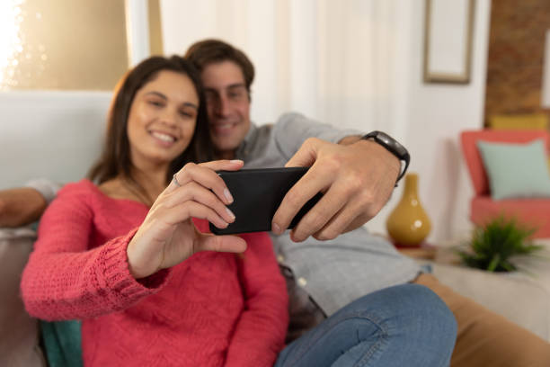 istock Young couple relaxing at home using a smartphone together 1183334401