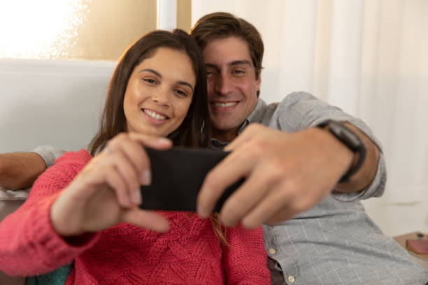 istock Young couple relaxing at home using a smartphone together 1183334418