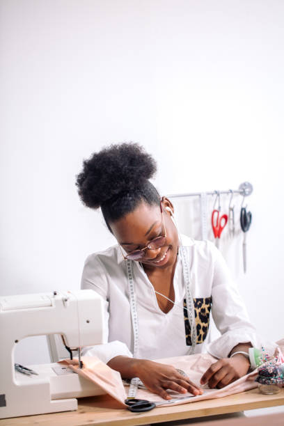 istock african seamstress working with fabric takes measures 1183335012