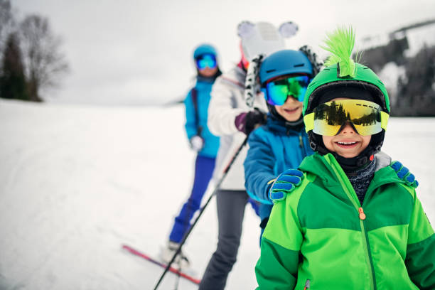 familie fährt am wintertag gemeinsam ski - skiurlaub stock-fotos und bilder