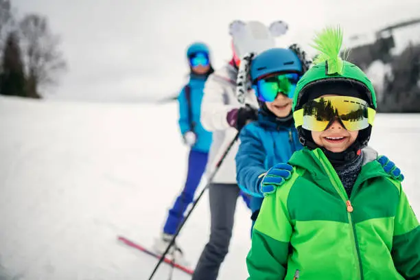 Photo of Family skiing together on winter day