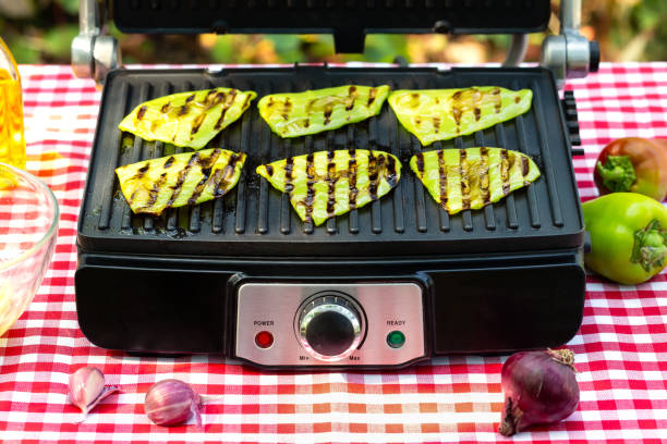 Green fried bell pepper lies on grill
