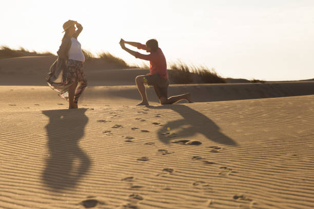Happy young spouse taking photos on beach