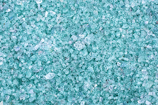 Fragments of blue glass. Small and sharp fragments of broken glass. cullet for creation of new glass are ready to be remelted. lot of particles of shattered glass. Garbage recycling.