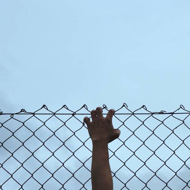 istock hand grabbing a metallic fence 1183341480