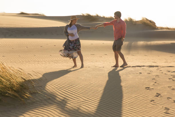 istock Happy young spouse holding hands together on beach 1183344752