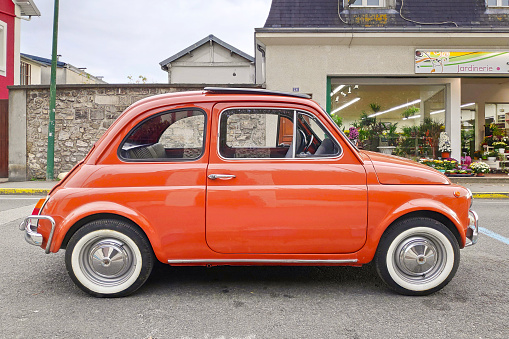 Lamorlaye, France - October 24 2019: The Fiat 500 (Italian: Cinquecento) is a rear-engined, four-seat, small city car that was manufactured and marketed by Fiat Automobiles from 1957 to 1975 over a single generation in two-door saloon and two-door station wagon bodystyles.