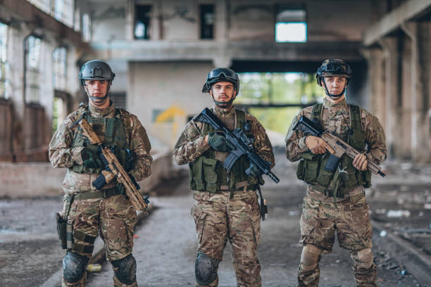 istock Army men standing in abandoned warehouse 1183347853