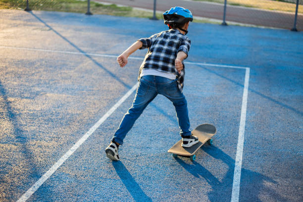 istock Young happy boy riding skateboard in the schoolyard 1183349761